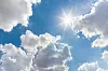 Sunny background, blue sky with white clouds and sun.