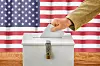 Man putting a ballot into a voting box – USA